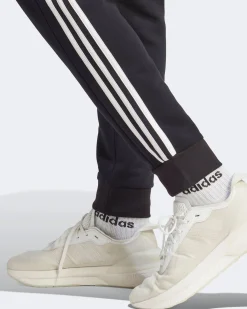 ADIDAS - PANTALONI ESSENTIALS FLEECE 3-STRIPES TAPERED CUFF - IB4030